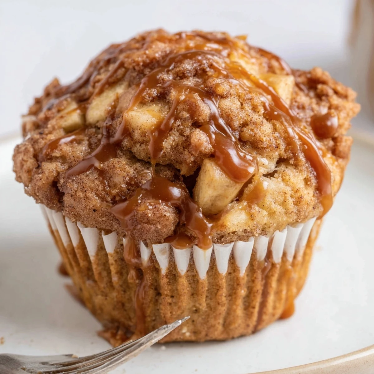 Freshly baked caramel apple kringle muffins with cinnamon swirls, perfect for dessert lovers.