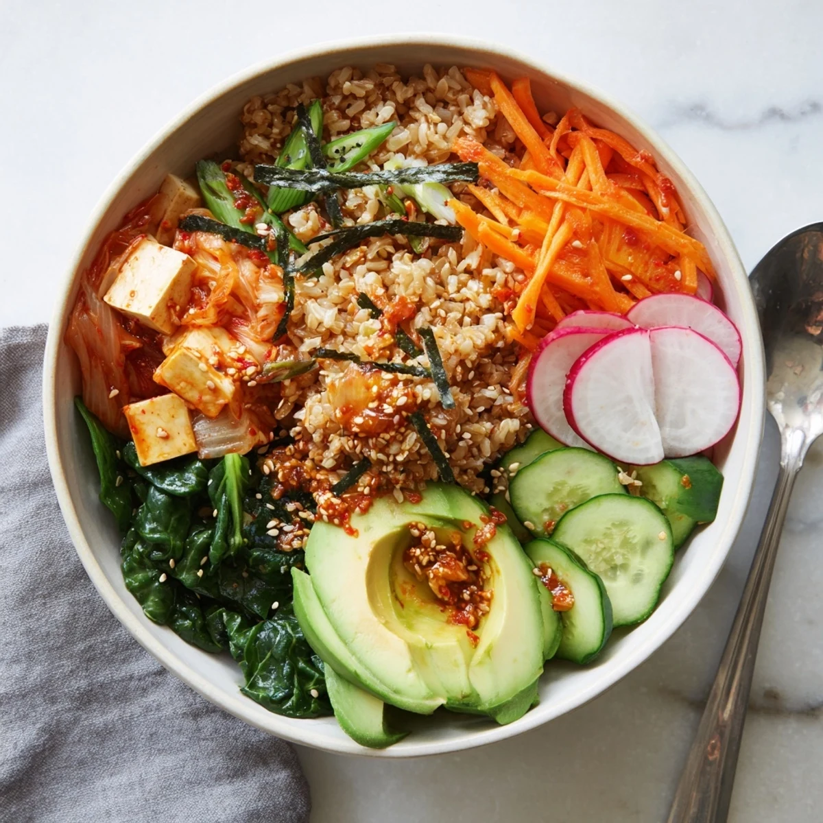 A colorful fermented vegetable bowl filled with kimchi, fresh veggies, and grains.  