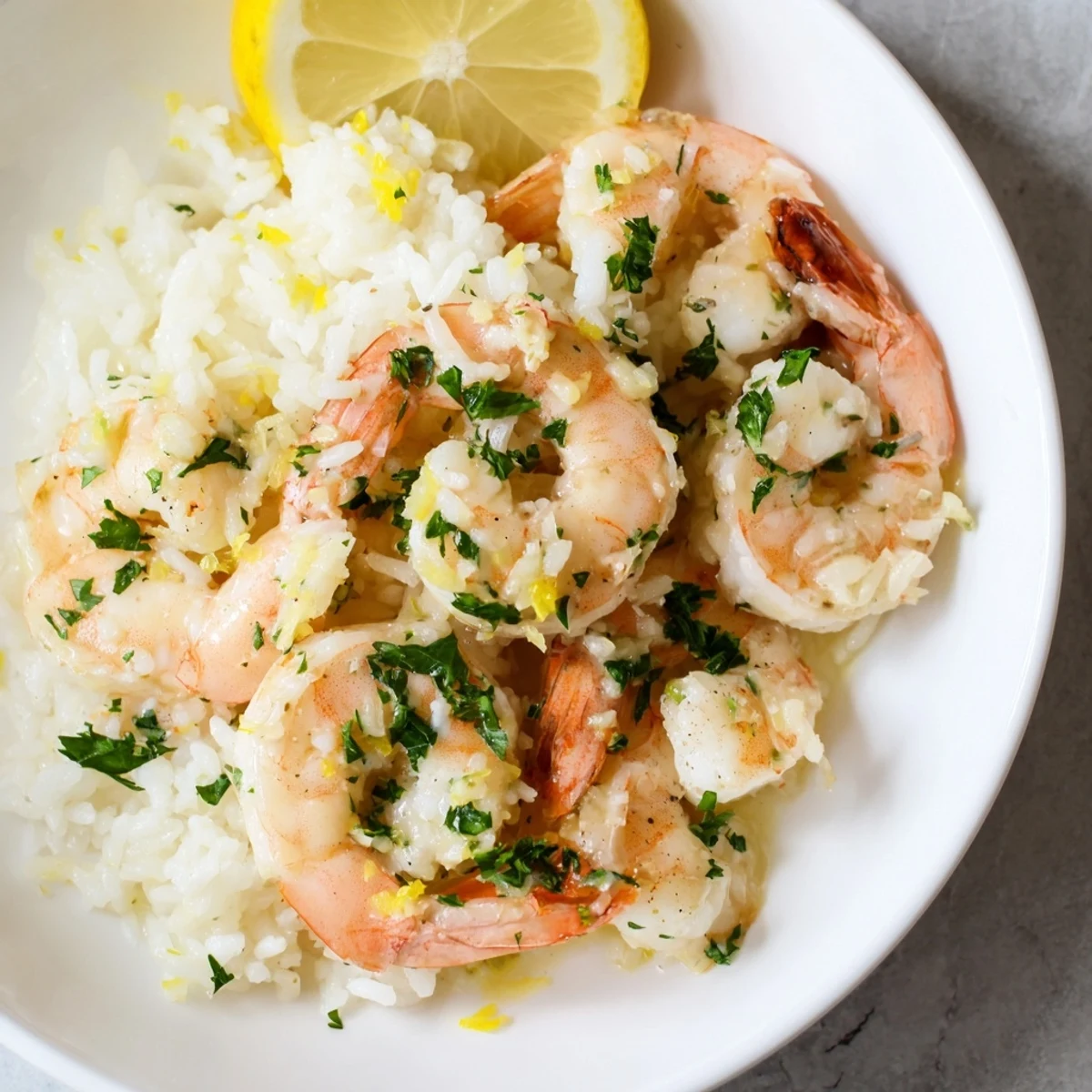 Golden garlic butter shrimp rice bowl, steaming and ready to eat, topped with fresh parsley.