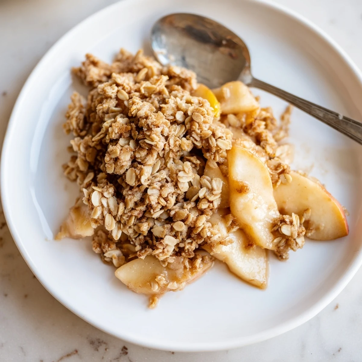Warm apple crisp emerges from the oven, showcasing soft apples and a sweet oat topping.