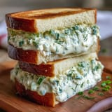 Elegant cucumber and cream cheese Benedictine tea sandwiches arranged on a silver platter, perfect for Kentucky Derby parties.