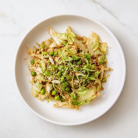 Steaming Cabbage Stir-Fry with Garlic and Soy sauce is ready—a colorful side dish with vibrant peas.