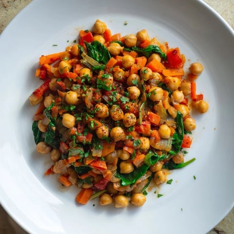 Sizzling Vegetarian Chickpea & Spinach Skillet topped with fresh parsley, ready to serve with crusty bread.