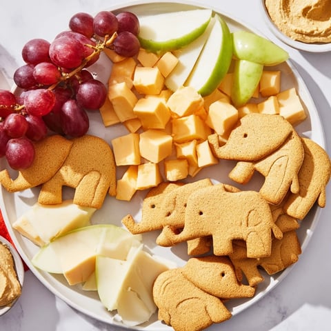 A colorful Gentle Giant Elephant Cracker Board: an appetizer filled with cheese, fruit, and crackers for sharing.