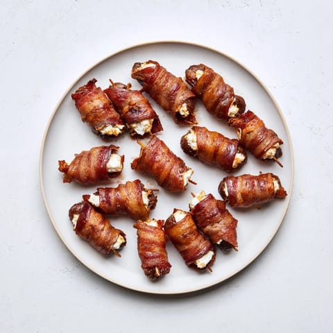 Savory bacon wraps sweet Medjool dates filled with goat cheese, perfect for an appetizer.