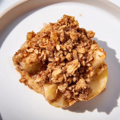 Freshly baked Best Apple Crisp: a close-up of tender apples under a crisp, oat-almond topping.