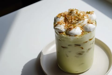 A refreshing close-up of the Toasted Coconut Gingerbread Iced Matcha, with visible ice cubes glimmering.