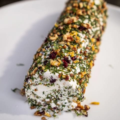 Vibrant image of the Winter Snowdrift Goat Cheese Log, ready to be served with crackers.