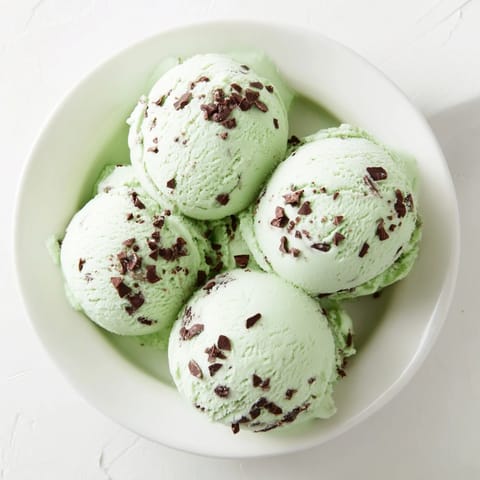 Creamy, green Mint Chocolate Chip Ice Cream, perfect for a hot day – imagine the refreshing taste.