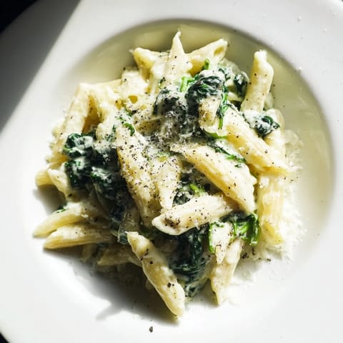 A bowl of delicious Creamy Spinach Pasta, perfectly coated pasta with vibrant green spinach and creamy sauce.