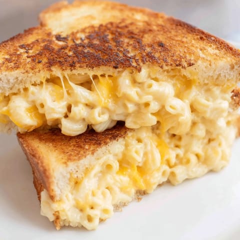 Crisp golden bread frames a gooey center of creamy macaroni and cheese in this Mac & Cheese Grilled Cheese, served hot and buttery.