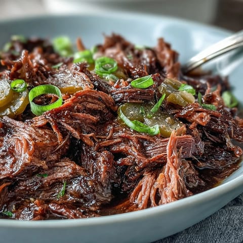 Fork-tender Slow Cooker Mississippi-Style Ranch Beef piled high on a toasted sandwich roll, melted provolone cheese dripping down the sides.