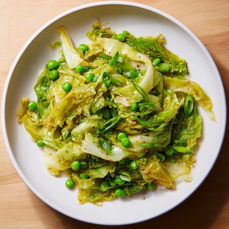 A delicious bowl of Cabbage Stir-Fry featuring fresh peas and fragrant garlic, ready for a flavorful bite.