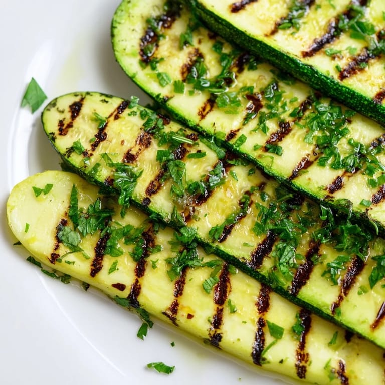 Golden-brown grilled Garlic Herb Zucchini, drizzled with olive oil and bursting with fresh herb flavors.