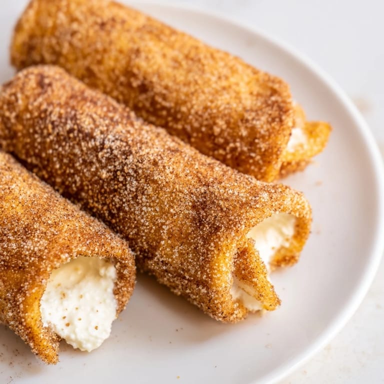 Mouthwatering image: Crispy, fried Easy French Toast Roll-Ups, showcasing the sweet cinnamon sugar coating on them.