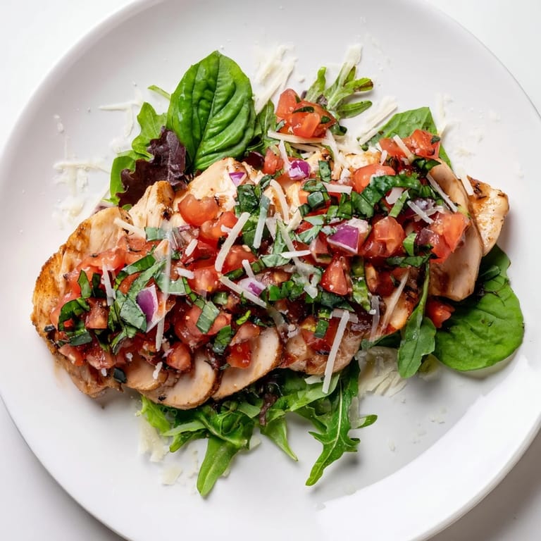 Plated Bruschetta Chicken Salad garnished with lemon wedges, ready for a light Italian-American lunch or dinner.